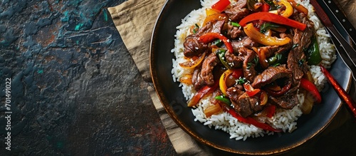 Stir fry Chinese pepper beef steak with onion red and green bell pepper rice in bowl. Creative Banner. Copyspace image photo
