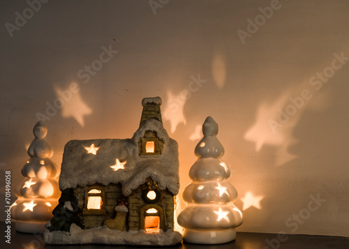 dekoracja świąteczna ze świateł, oświetlony domek i choinki ze światłem.