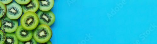 Closeup of fresh food fruit shapes of kiwi on one side isolated on bright blue background banner