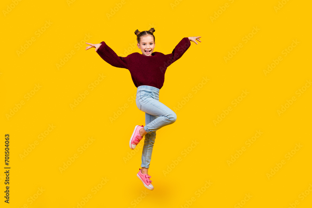 Full length portrait of energetic overjoyed schoolchild jump empty space isolated on yellow color background