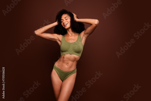 No filter studio photo of seductive shiny woman wear lingerie hands head enjoying haircare empty space isolated brown color background