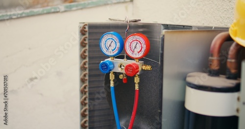 Close up of ac gauges vacuum pump used for checking air conditioner freon in need of maintenance. Set of refrigerant levels pressure measurement device mounted on HVAC system © DC Studio
