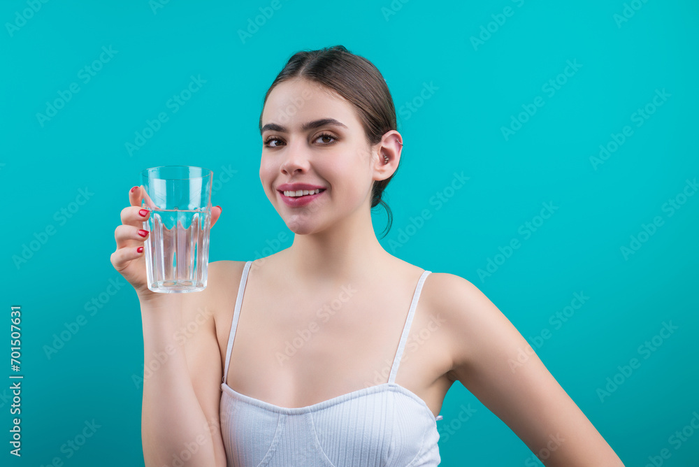 Woman drinking water, isolated on studio background. Portrait of happy smiling young woman with glass of fresh water. Thirsty girl. Refreshing. Water balance. Woman drinking water, isolated on studio background. Portrait of happy smiling young woman with glass of fresh water. Thirsty girl. Refreshing. Water balance.