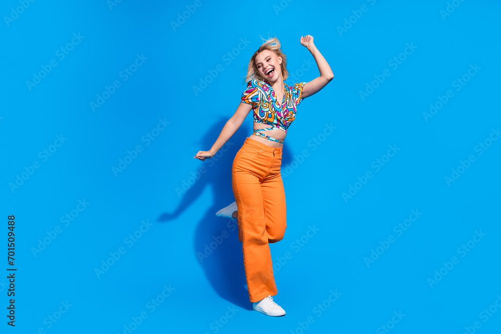 Full length photo of positive pretty person enjoy dancing have good mood isolated on blue color background Full length photo of positive pretty person enjoy dancing have good mood isolated on blue color background