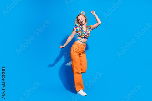 Full length photo of positive pretty person enjoy dancing have good mood isolated on blue color background