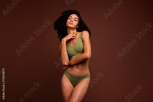 No retouch photo of adorable girl wear top and panties posing showing strong athletic perfect shape isolated on brown color background © deagreez