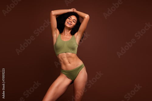 No filter photo of cheerful happy slender girl nice figure wear top panties posing empty space isolated on brown color background