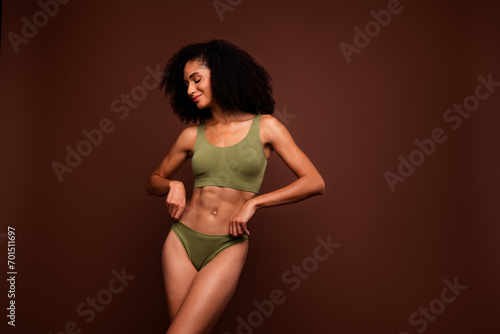 No filter studio photo of cheerful dreamy woman wear lingerie loving herself empty space isolated brown color background © deagreez