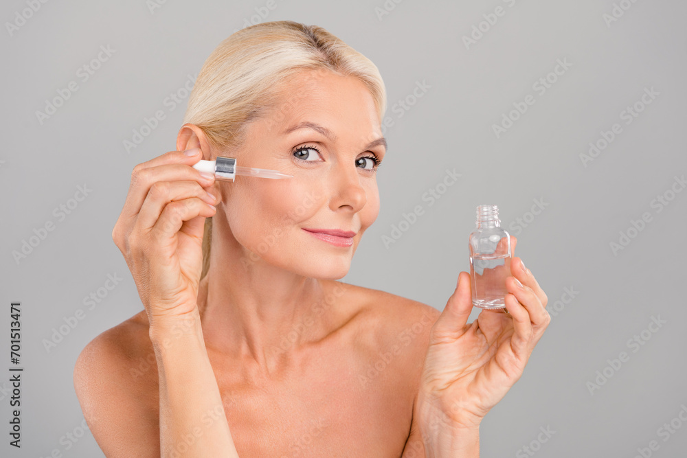 Portrait of attractive gentle lady care perfect face soft skin apply anti age complex collagen vitamin isolated on gray color background Portrait of attractive gentle lady care perfect face soft skin apply anti age complex collagen vitamin isolated on gray color background
