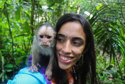 Photography young latina explorer taking selfie with monkey in the jungle