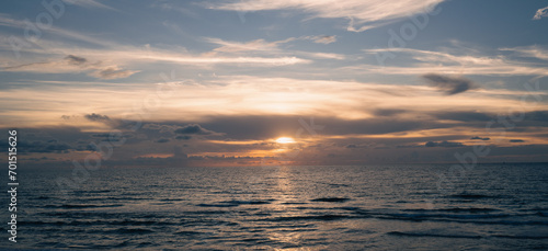 Sunset on sea. Ocean beach sunrise with calm cloudy sky.