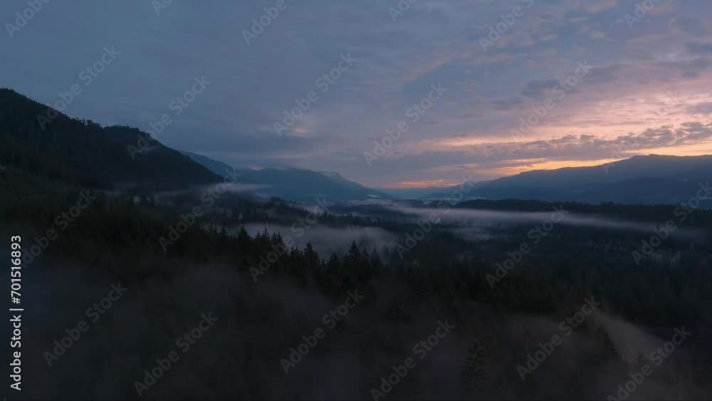 Valley by Mountains and Green Trees covered in fog. Canadian Landscape Nature Aerial Background. Vancouver Island, British Columbia, Canada. Valley by Mountains and Green Trees covered in fog. Canadian Landscape Nature Aerial Background. Vancouver Island, British Columbia, Canada.
