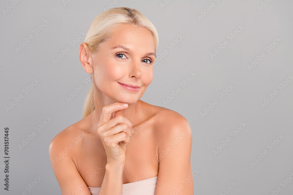 Photo of cute adorable old woman naked shoulders arm chin empty space isolated grey color background Photo of cute adorable old woman naked shoulders arm chin empty space isolated grey color background