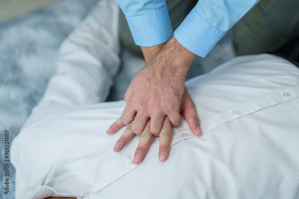 Close up man lying down while another individual, likely a medical professional, is performing a CPR chest compression, potentially in response to heart attack. Close up man lying down while another individual, likely a medical professional, is performing a CPR chest compression, potentially in response to heart attack.