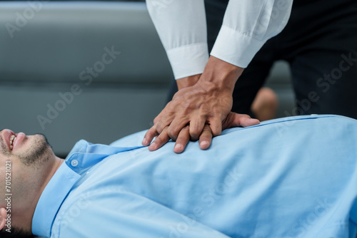 Close up man lying down while another individual, likely a medical professional, is performing a CPR chest compression, potentially in response to heart attack.