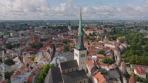 Aerial view of tall church tower and historic houses in old town. Medieval tourist sight Oleviste kogudus. Tallinn, Estonia photo