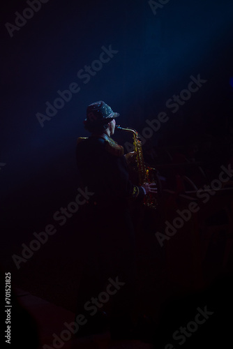 Handsome african american jazz musician playing the saxophone in the studio on a neon background. Musical concept. Joyful young attractive boy improvising. Retro close-up portrait.