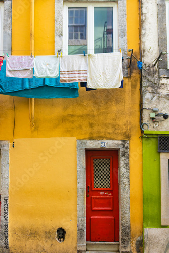 Red dor and clothes line on a yellow wall, Lisbon, Portugal photo