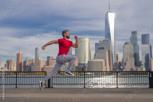 Sport runner. Man running. Fit male sport fitness model sprinting outdoors. Attractive man running fast, workout outdoors, runner jogging over street in NYC. Fitness, health man running on street.