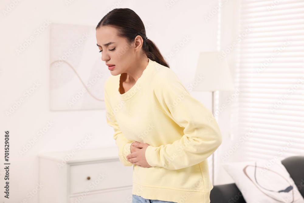 Woman suffering from abdominal pain at home. Unhealthy stomach Woman suffering from abdominal pain at home. Unhealthy stomach