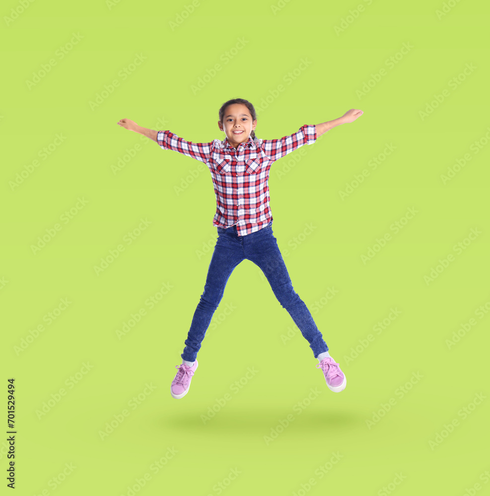Cute girl jumping on yellowish green background