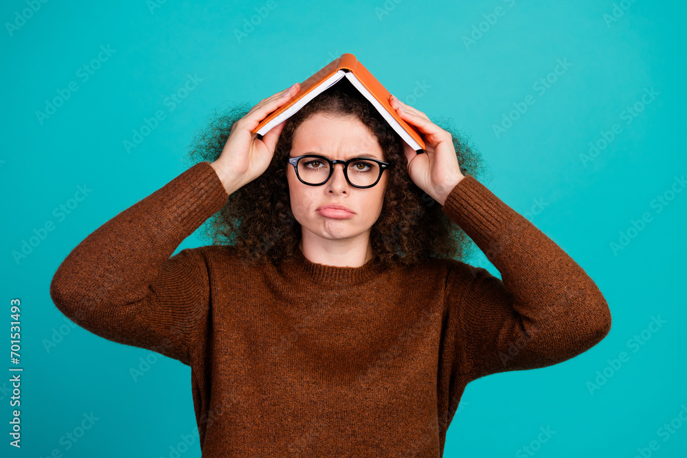 Photo portrait of pretty young girl hold book roof upset boring moody dressed stylish brown outfit isolated on aquamarine color background Photo portrait of pretty young girl hold book roof upset boring moody dressed stylish brown outfit isolated on aquamarine color background
