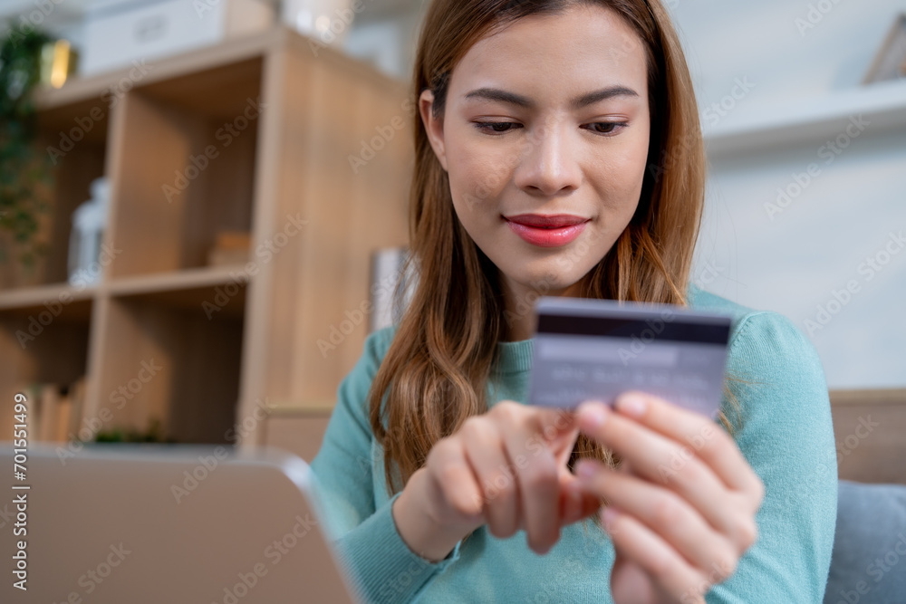 A woman express on her face with cheerful, conveying a sense of satisfaction and happiness with her online shopping and successful credit card transactions. A woman express on her face with cheerful, conveying a sense of satisfaction and happiness with her online shopping and successful credit card transactions.