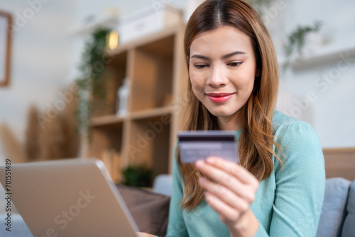 A woman express on her face with cheerful, conveying a sense of satisfaction and happiness with her online shopping and successful credit card transactions.