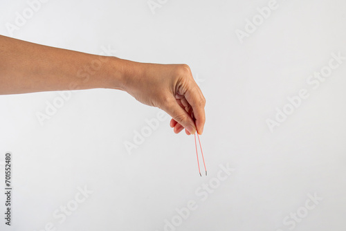 Pink hair tweezers in hand isolated on white background