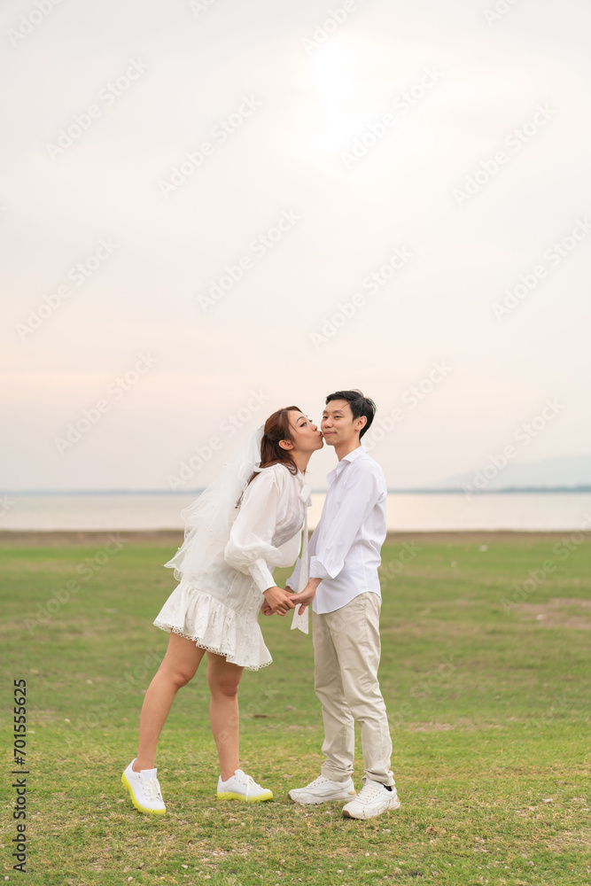 Happy young Asian couple in bride and groom clothing Happy young Asian couple in bride and groom clothing