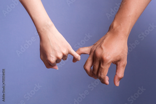 Two people holding hands. Young love couple pinky promise or pinky swear.  photo
