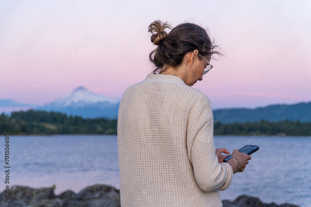 Naklejka premium Woman chatting on a smartphone outdoors.