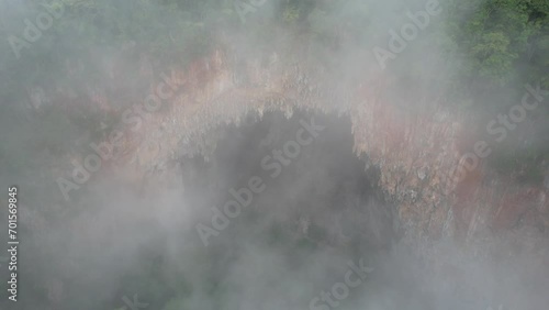 Aerial landscape view of the fog over the Spirit Well cave by drone, Mae Hong Son, Thailand