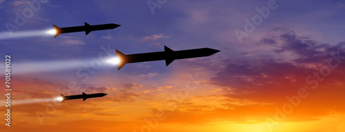Fired missiles fly to the target. Missiles at the sky at sunset. Missile defense. Rockets attack concept.