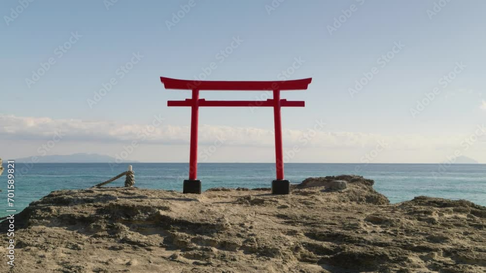 Calm and relaxing scenery with Japanese Torii gate against ocean on top of rock Calm and relaxing scenery with Japanese Torii gate against ocean on top of rock