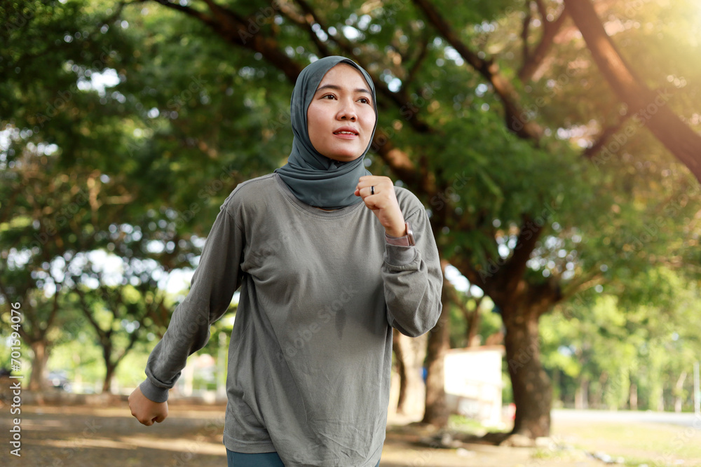Portrait of asian muslim girl enjoy jogging in the morning in the garden field Portrait of asian muslim girl enjoy jogging in the morning in the garden field