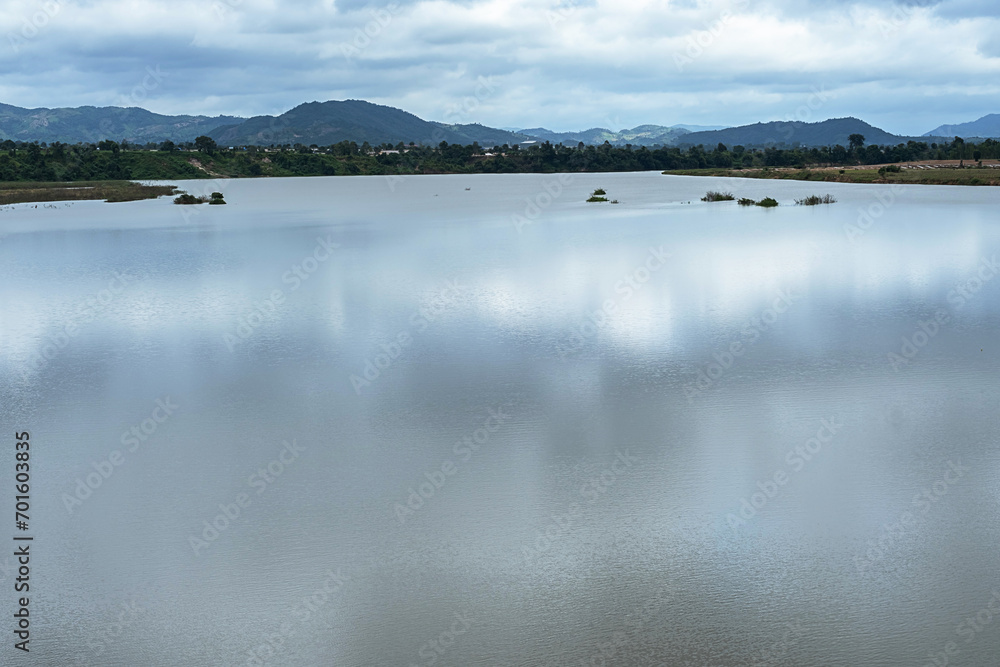 Reflection of clouds on lake surrounded by mountains.