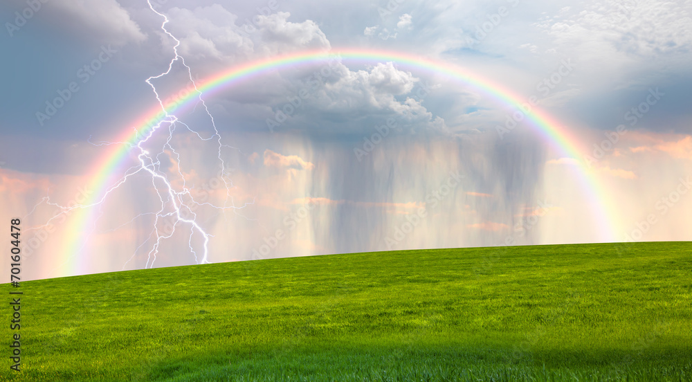 Lightning strikes between stormy clouds with green grass field and rainbow Lightning strikes between stormy clouds with green grass field and rainbow