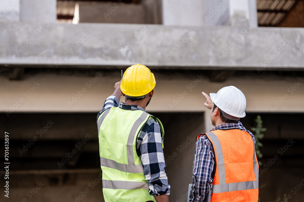 Asian people, two man, holding blueprints Structural engineers examine structural plans for office buildings and housing developments on-site, discussing work at construction site. Asian people, two man, holding blueprints Structural engineers examine structural plans for office buildings and housing developments on-site, discussing work at construction site.