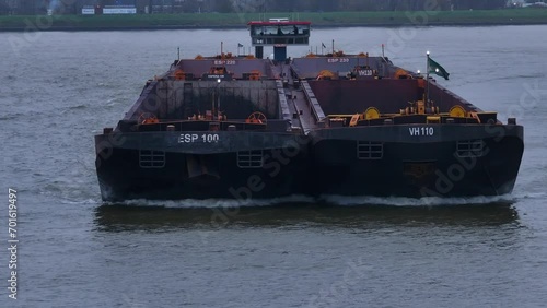 Goods barge sailing across Oude Maas river, vessel deck vacant for cargo photo