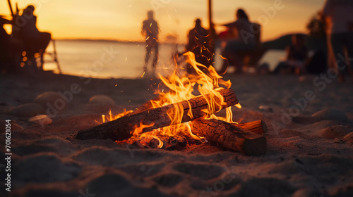 closeup of a bonfire in front of the beach on a nice evening with young people enjoying life 