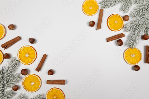 Christmas composition, dried orange slices, fir tree branches, cinnamon sticks, hazelnuts on white background. Christmas, New Year, winter concept. Top view, flat lay, copy space.