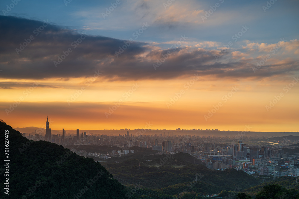 In serene sunset tones, stunning views of the Taipei skyline are highlighted by the iconic Taipei 101 tower. Xizhi Dajianshan, Taiwan.