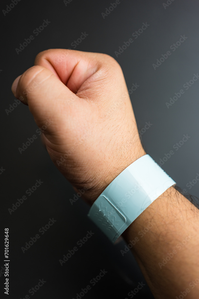 Fototapeta premium Empty concert bracelet on hand, mockup on a black background. Event ticket concept