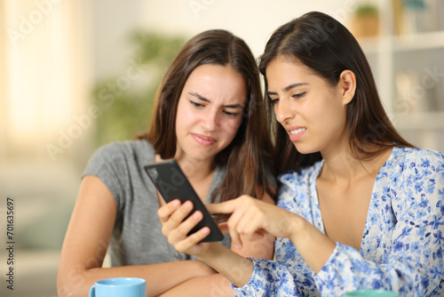 Disgusted friends watching media content on phone