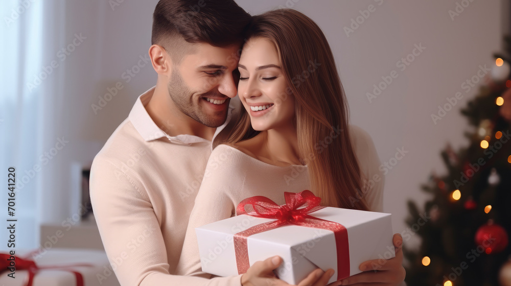 Lovely young couple hugging at home holding gift box, happy giving concept. Lovely young couple hugging at home holding gift box, happy giving concept.