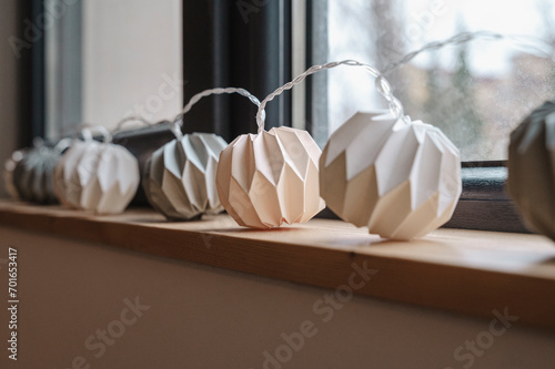 White paper garland decorated on window sill photo