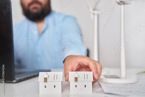 Architect working with house models at desk in office photo
