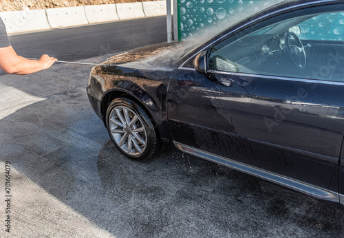 Car washing under the open sky. High-pressure washing car outdoors. © Denis Rozhnovsky