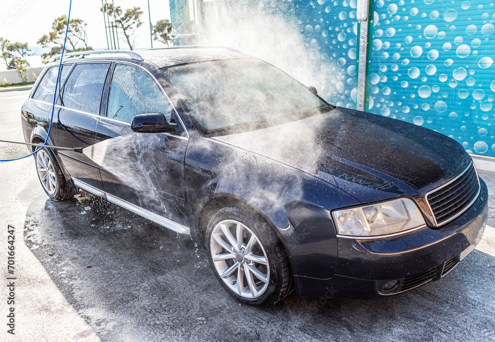 Car washing under the open sky. High-pressure washing car outdoors.